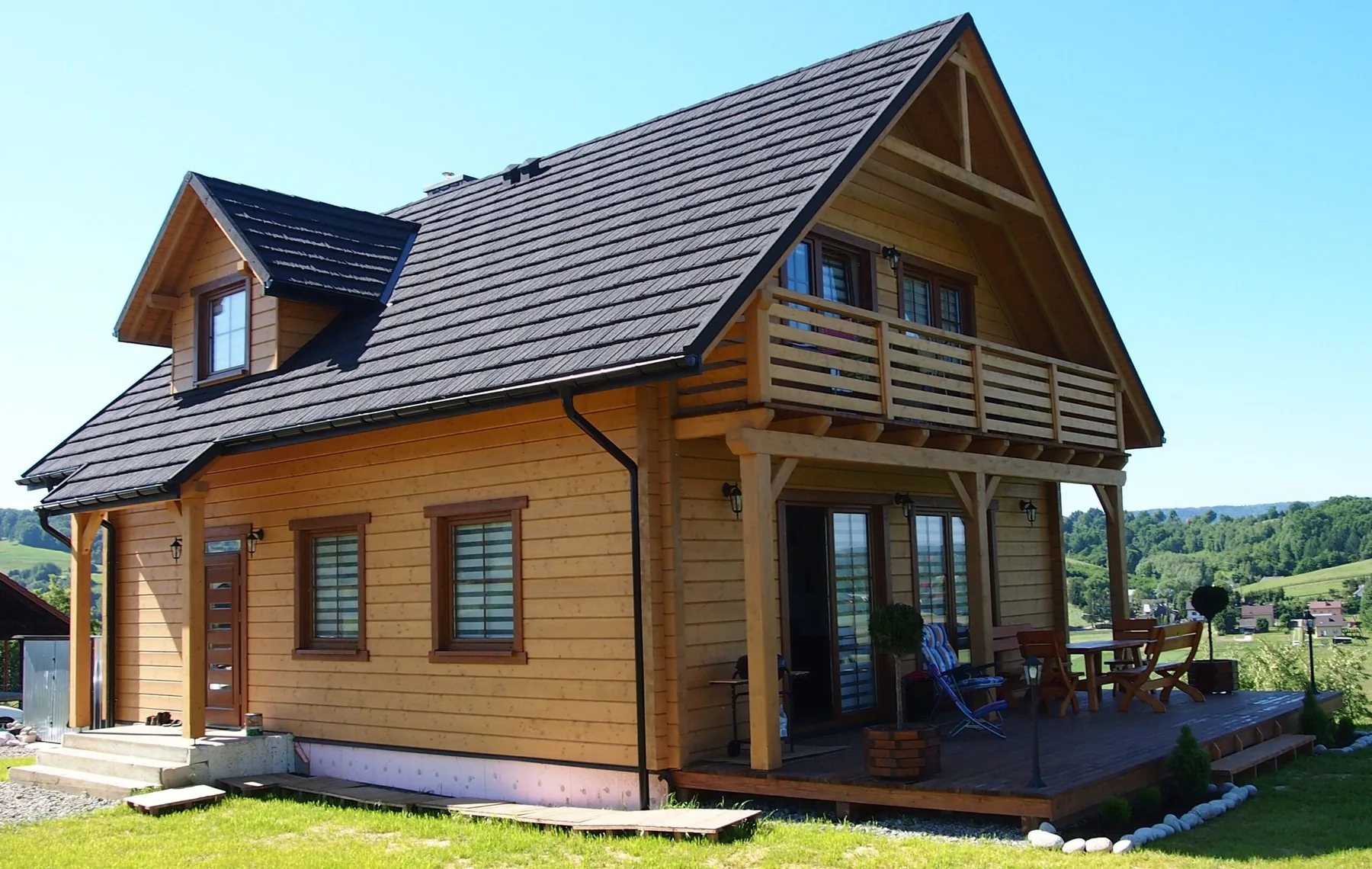 Completed log home with a graphite roof and covered entrance